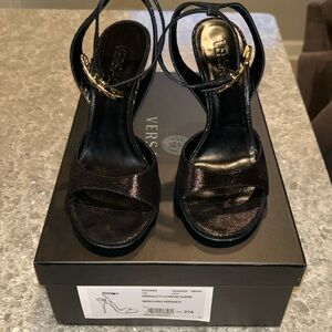 Versace black micro-suede leather heels with gold safety pin buckle.